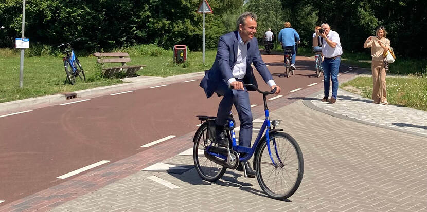 Afbeelding: Minister Harbers (Infrastructuur en Waterstaat) op een blauwe fiets